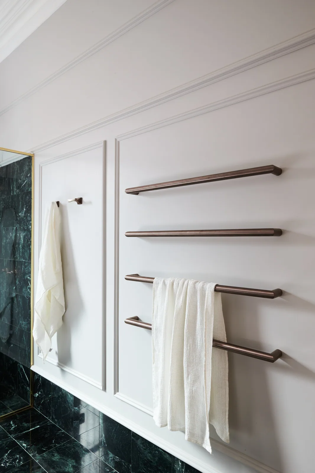 Bathroom with brass fixtures, and wainscoting—mouldings frame the space with classic proportions and tactile charm.