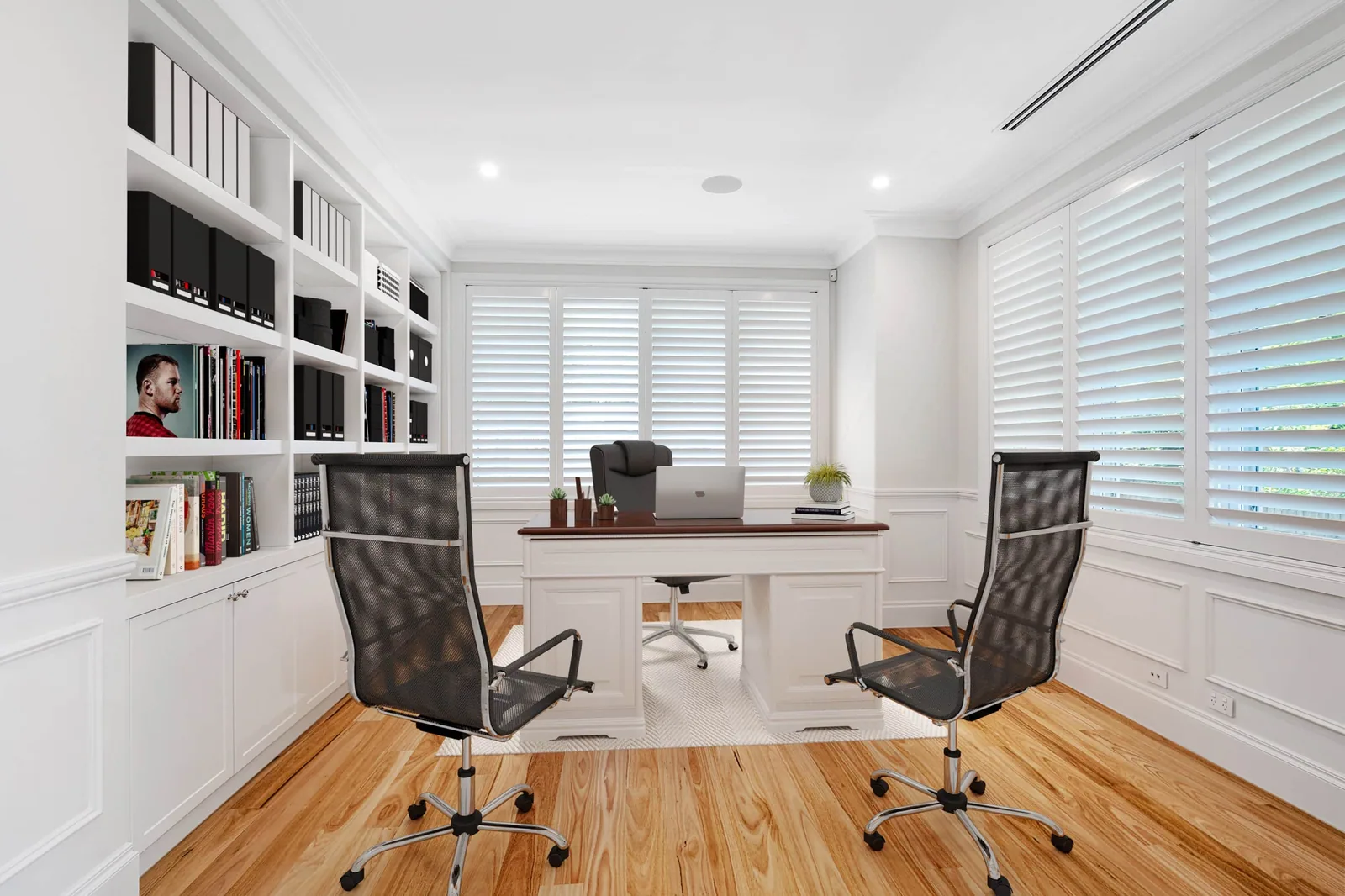 Beautifully styled Modern Hamptons home office featuring timber floors, white walls with wainscoting, floor to ceiling bookshelf, white timber table and black office chairs