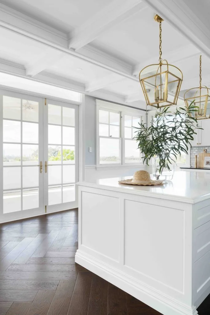 Modern kitchen island with white coffered ceiling and feature gold pendant light