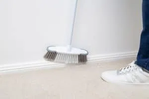 A broom dusting skirting boards