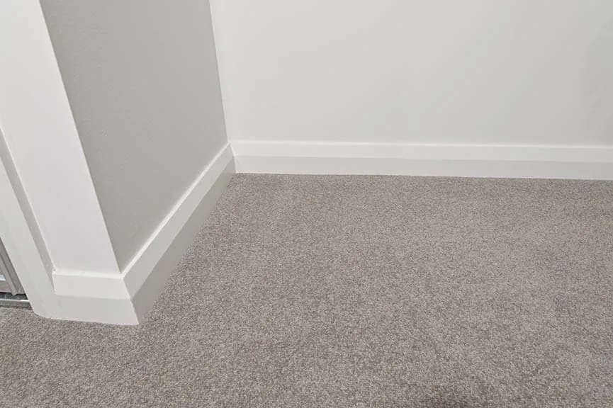 Standard specification skirting and architrave in a simple square-set profile within a neutral interior.