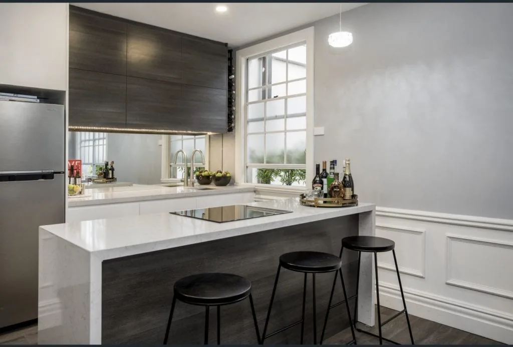 1920s-inspired modern kitchen design with dark grey panelling and detailed wainscoting