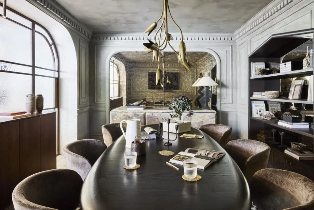 A stylish office with a dark wood boardroom table and decorative timber mouldings adorning the limewashed walls.