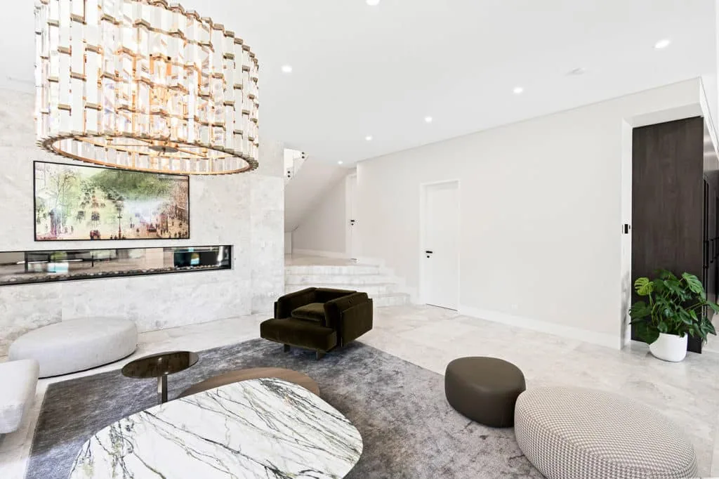 Bright minimalist living room featuring marble tiling, crisp white walls, and Intrim's SK800 Shadowline skirting and door jamb system for a refined modern aesthetic.