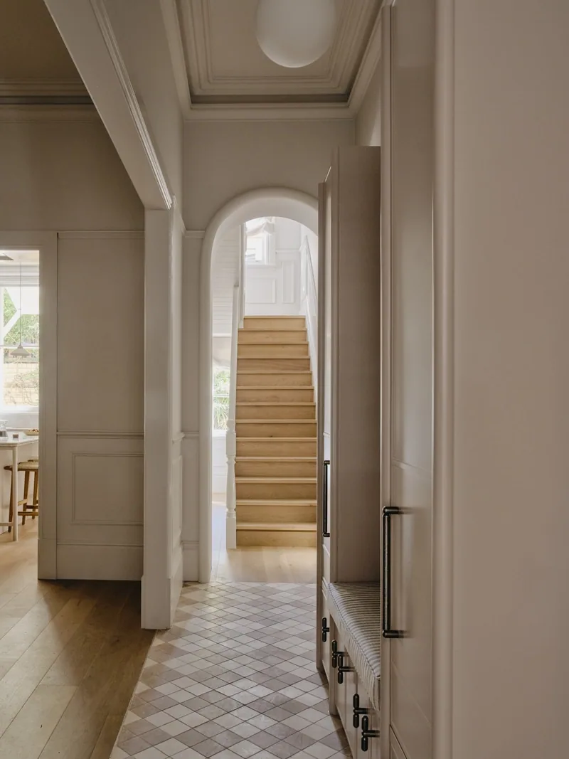 Entry hall with archway and ceiling cornice in Potts Point renovation by Convict Interiors, highlighting Intrim mouldings and panelling