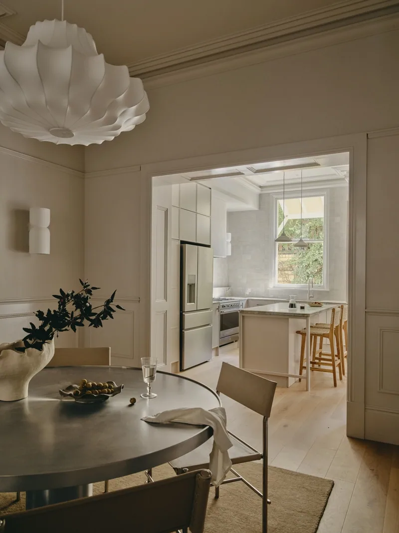 Dining room opening to kitchen in Victorian terrace Potts Point renovation by Convict Interiors featuring Intrim wall panelling, skirting and architraves