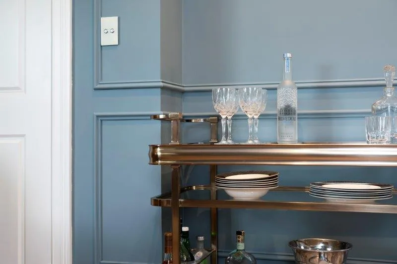Close up of 1920s-style blue wall panelling with a drinks tray in the foreground